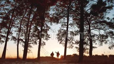 两名游客剪影日落在森林阳光下徒步旅行。 旅游观光旅游观光旅游观光旅游观光旅游团体
